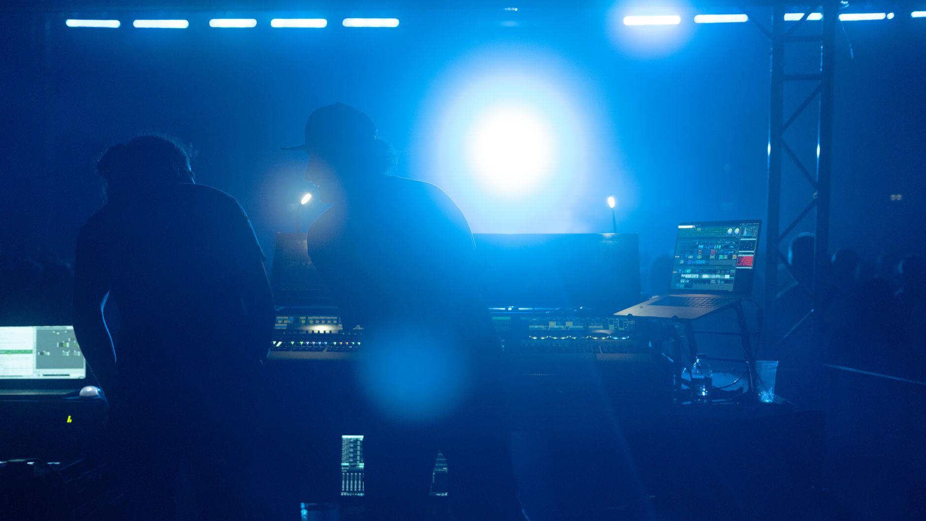 Silhouetted sound engineers working at concert in İstanbul, capturing the vibrant nightlife atmosphere.