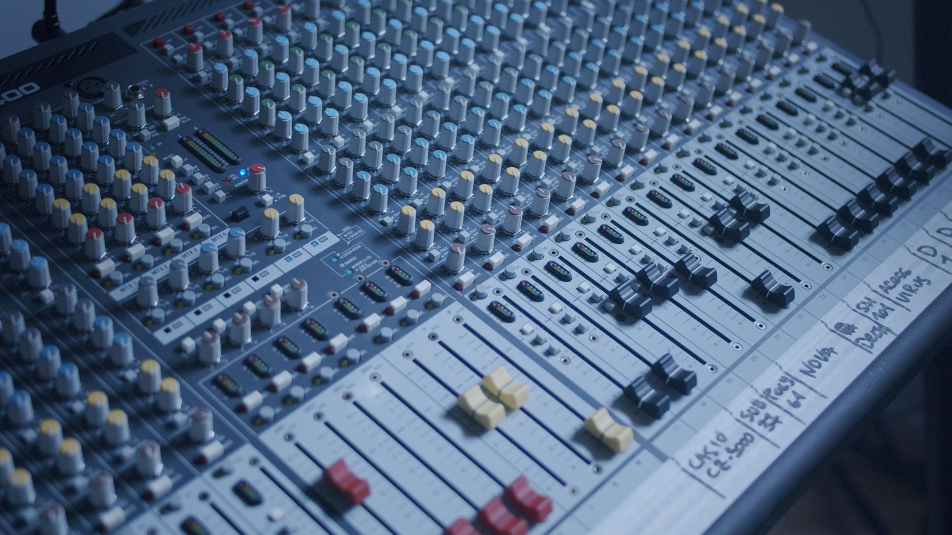 Detailed view of a professional audio mixer in a recording studio setting.