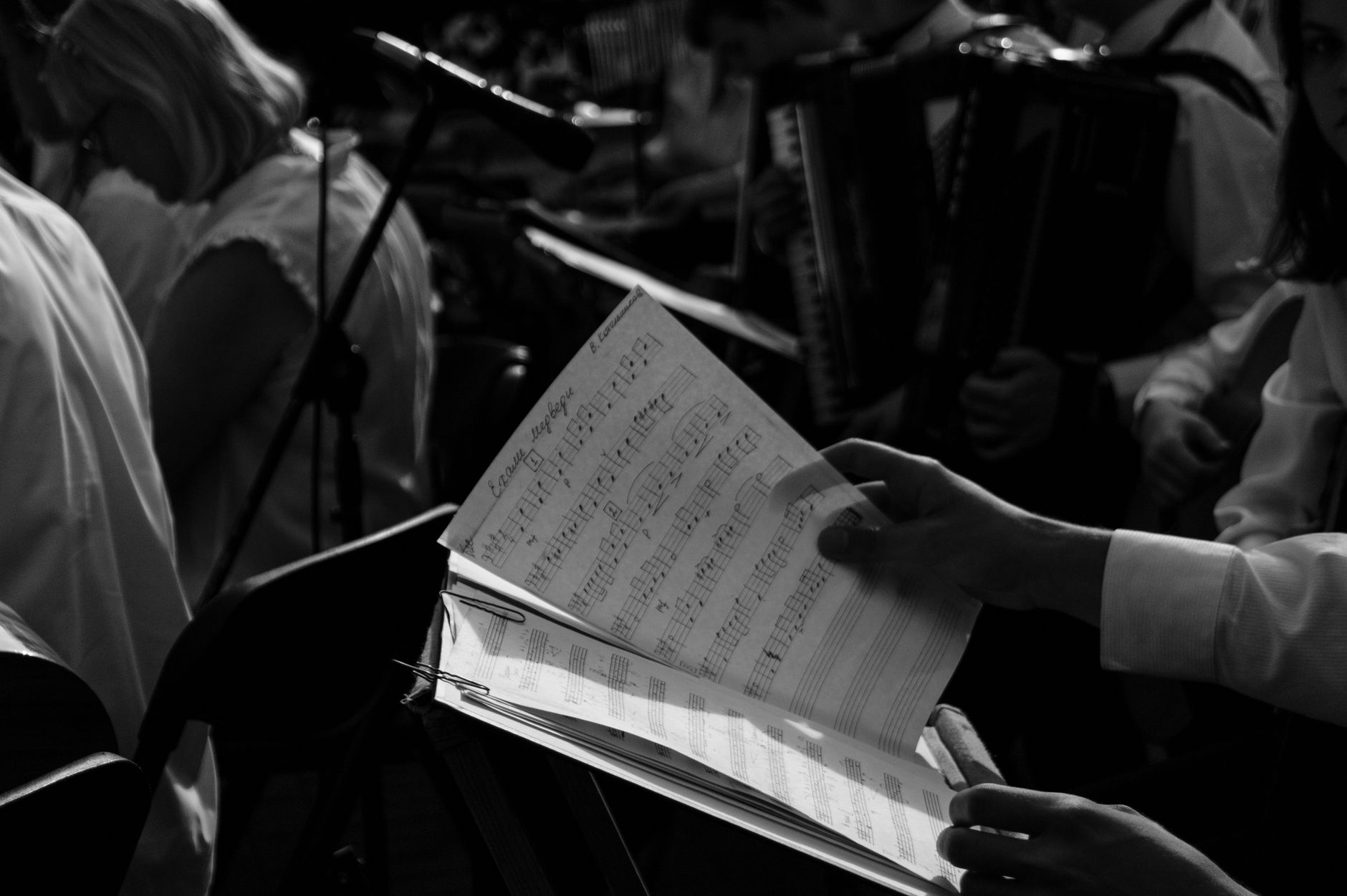 Black and white photo of musicians rehearsing with sheet music.